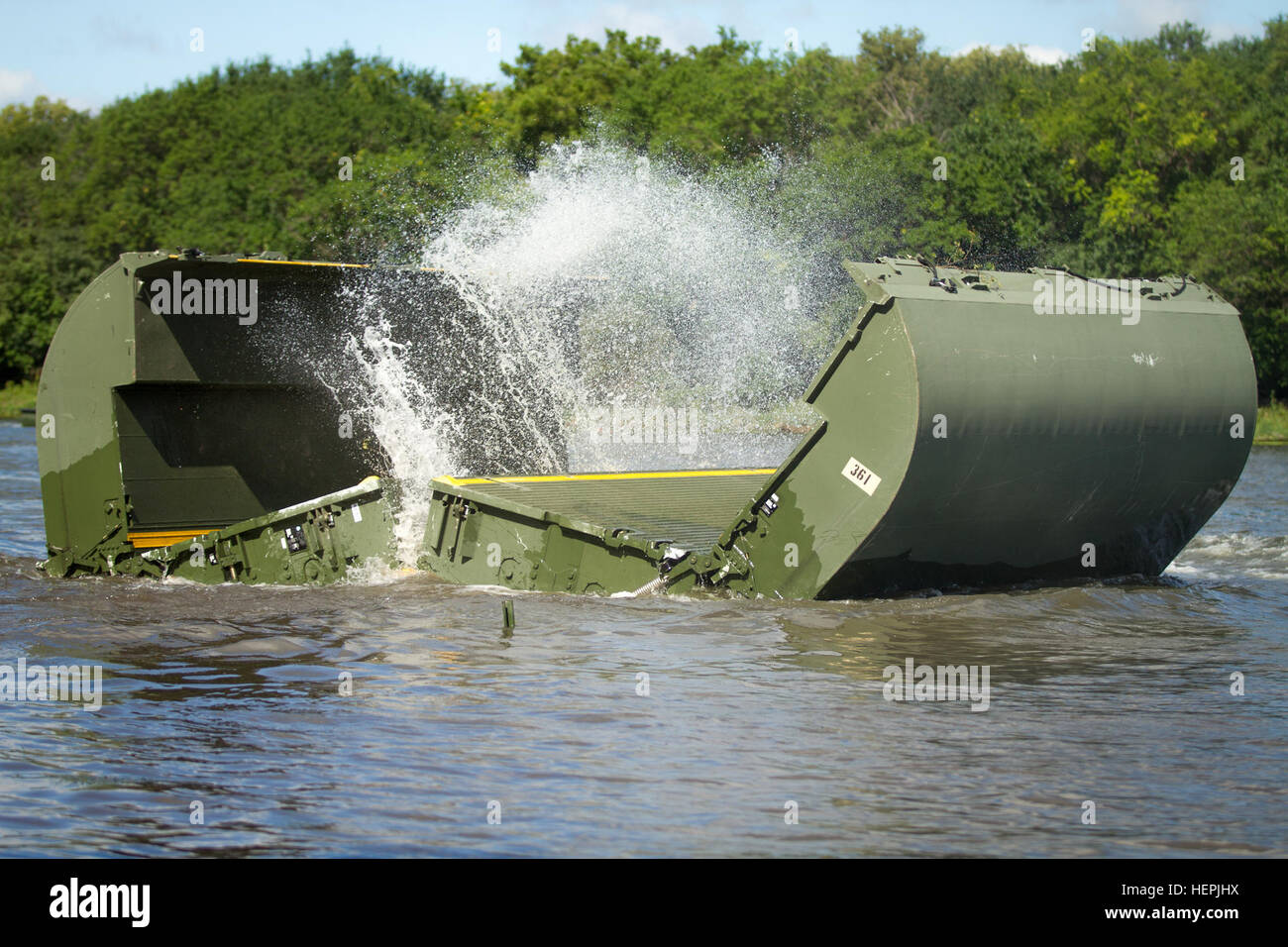 An Improved Float Bridge interior bay section assigned to the 671st Engineer Company, 416th Theater Engineer Command, Portland, Ore., automatically deploys after being released from the back of a M1120 Heavy Expanded Mobility Tactical Truck as part of a bridging exercise at Joliet, Wis., Aug. 20, 2015. The 671st was participating in Red Dragon, part of the 84th Training Command’s third and final Combat Support Training Exercise of the year hosted by the 86th Training Division at Fort McCoy, Wis. (U.S. Army photo by Sgt. Robert Farrell/Released) 671st Engineer Company bridging 150820-A-TW638-28 Stock Photo