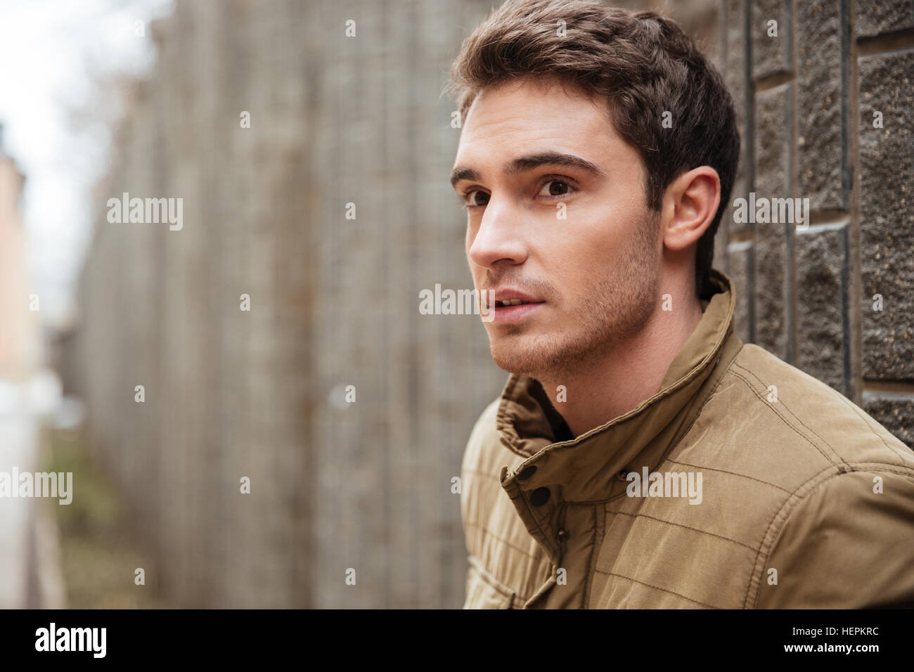 picture-of-attractive-young-man-walking-on-the-street-and-looking-aside