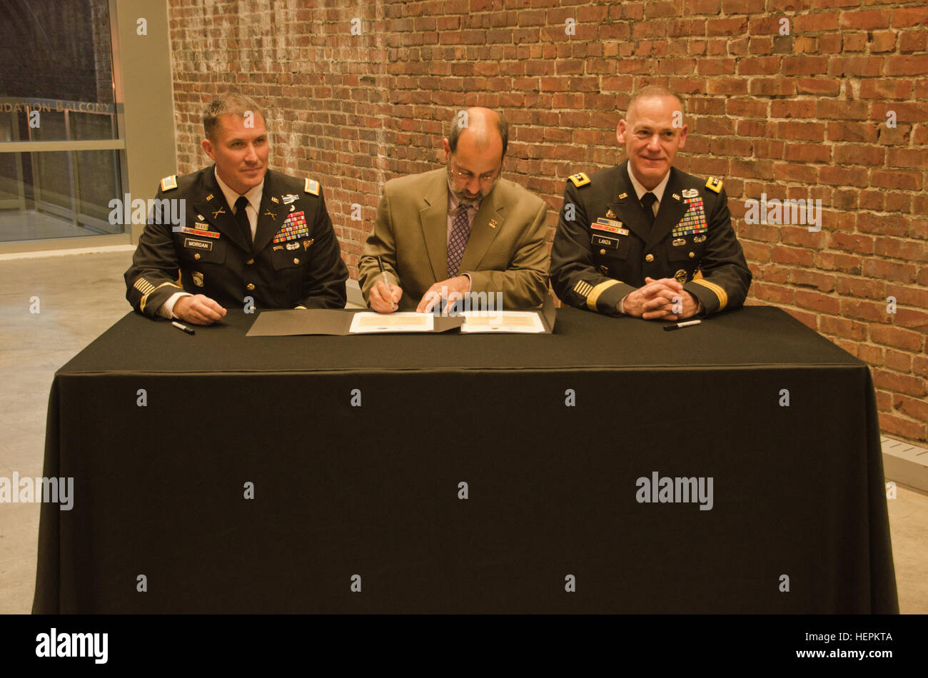 Col. Daniel S. Morgan, commander, Joint Base Lewis-McChord, left, Mark A. Pagano, chancellor, University of Washington-Tacoma, center, and Lt. Gen. Stephen R. Lanza, commanding general, I Corps, JBLM, right, come together to sign partnership resolutions at the UW-T, Oct. 29, 2015. Both JBLM and I Corps signed partnership resolutions with the UW-T agreeing to become a model university and military institutional partnership. (U.S. Army photo by Sgt. Jasmine Higgins, 28th Public Affairs Detachment) Partnership 151030-A-HS859-946 Stock Photo