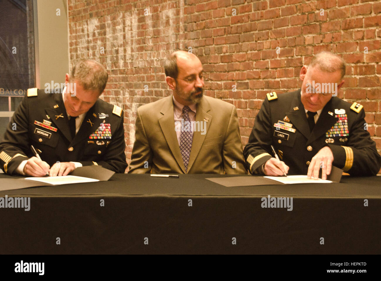 Col. Daniel S. Morgan, commander, Joint Base Lewis-McChord, left, Mark A. Pagano, chancellor, University of Washington-Tacoma, center, and Lt. Gen. Stephen R. Lanza, commanding general, I Corps, JBLM, right, come together to sign partnership resolutions at the UW-T, Oct. 29, 2015.  Both JBLM and I Corps signed partnership resolutions with the UW-T agreeing to become a model university and military institutional partnership. (U.S. Army photo by Sgt. Jasmine Higgins, 28th Public Affairs Detachment) Sign 151030-A-HS859-059 Stock Photo
