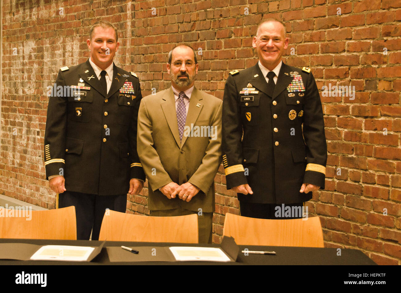 Col. Daniel S. Morgan, commander, Joint Base Lewis-McChord, left, Mark A. Pagano, chancellor, University of Washington-Tacoma, center, and Lt. Gen. Stephen R. Lanza, commanding general, I Corps, JBLM, right, come together to sign partnership resolutions at the UW-T, Oct. 29, 2015. Both JBLM and I Corps signed partnership resolutions with the UW-T agreeing to become a model university and military institutional partnership. (U.S. Army photo by Sgt. Jasmine Higgins, 28th Public Affairs Detachment) Signing 151030-A-HS859-119 Stock Photo