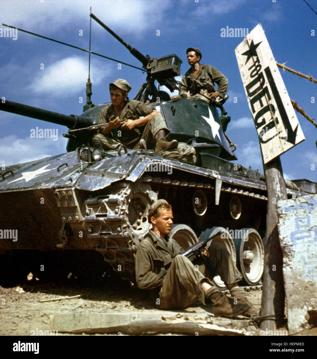 Crew of an M-24 tank along the Naktong River front.  On the ground is Pfc. Rudolph Dotts, Egg Harbor City, N.J. gunner (center); Pvt. Maynard Linaweaver, Lundsburg, Kansas, cannoner; and on top is Pfc. Hugh Goodwin, Decature, Miss., tank commander. All are members of the 24th Reconnaissance, 24th Division. NARA FILE#:  111-C-6061 HA-SC-98-06983-Crew of M24 along Naktong River front-Korean war-17 Aug 1950 Stock Photo