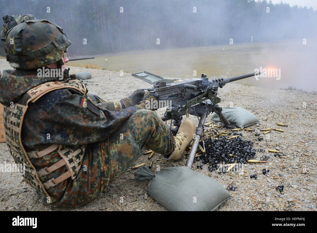 A German soldier fires a .50-caliber machine gun during a familiarization training on U.S. weapons at the 7th Army Joint Multinational Training Command Grafenwoehr Training Area, Germany, Dec. 9, 2015. (U.S. Army photo by Visual Information Specialist Gertrud Zach/released) CATC trains German soldiers on U.S. weapons 151209-A-HE539-0669 Stock Photo