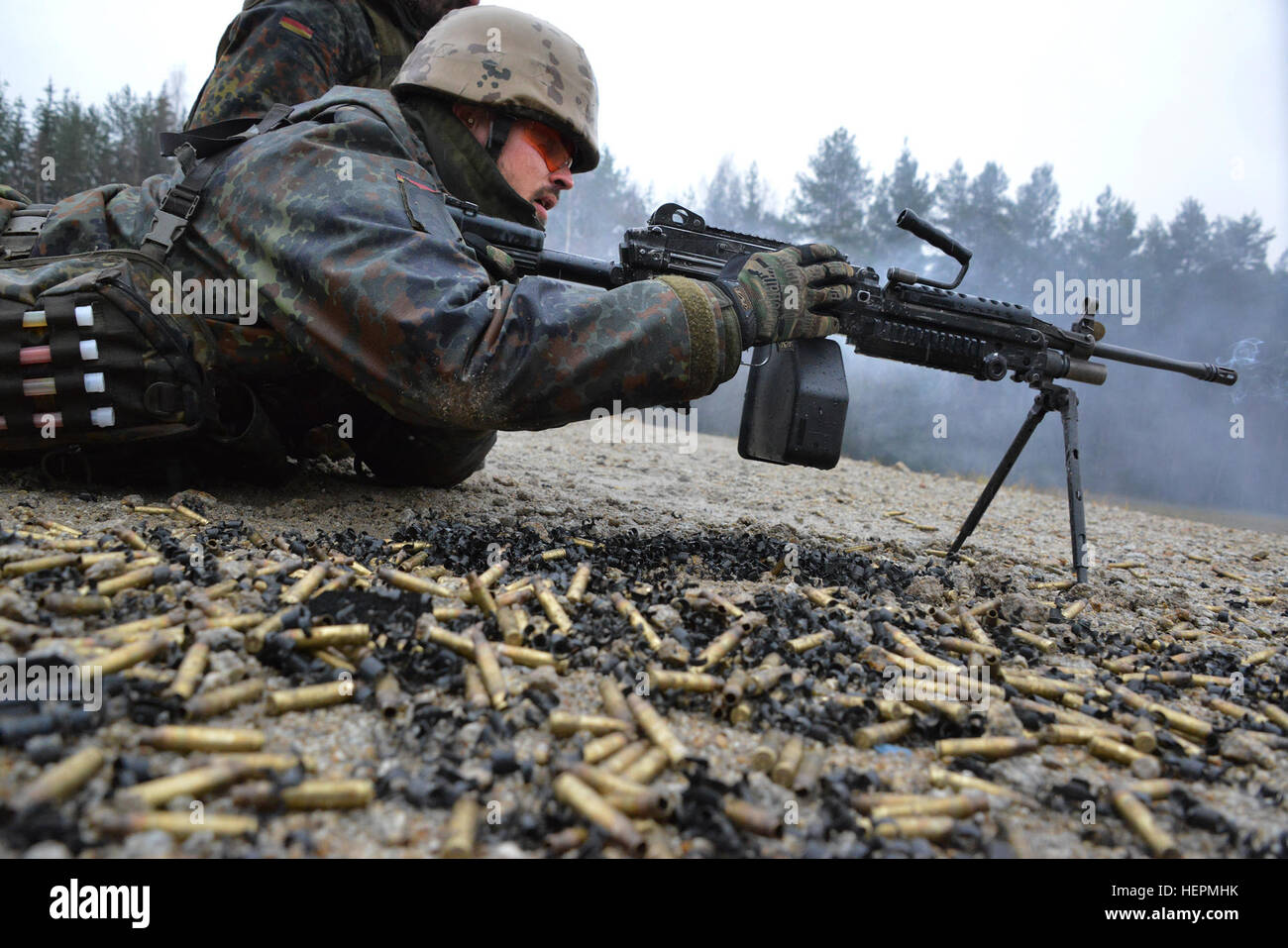 A German soldier fires a M249 light machine gun during a familiarization training on U.S. weapons at the 7th Army Joint Multinational Training Command Grafenwoehr Training Area, Germany, Dec. 9, 2015. (U.S. Army photo by Visual Information Specialist Gertrud Zach/released) CATC trains German soldiers on US weapons 151209-A-HE359-0217 Stock Photo