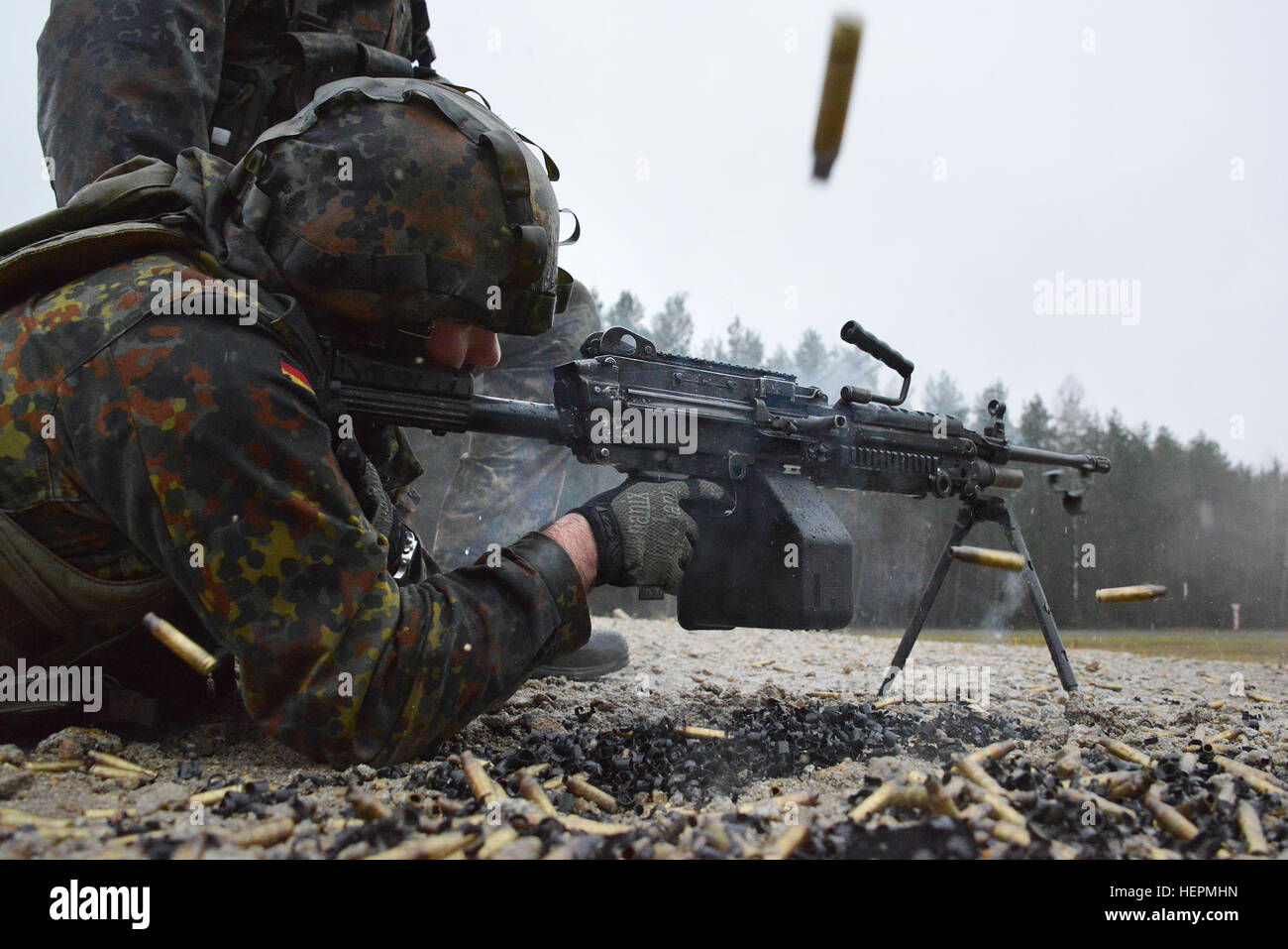 A German soldier fires a M249 light machine gun during a familiarization training on U.S. weapons at the 7th Army Joint Multinational Training Command Grafenwoehr Training Area, Germany, Dec. 9, 2015. (U.S. Army photo by Visual Information Specialist Gertrud Zach/released) CATC trains German soldiers on US weapons 151209-A-HE539-0205 Stock Photo