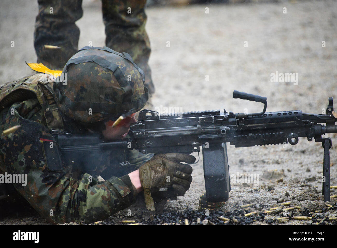 A German soldier fires a M249 light machine gun during a familiarization training on U.S. weapons at the 7th Army Joint Multinational Training Command Grafenwoehr Training Area, Germany, Dec. 9, 2015. (U.S. Army photo by Visual Information Specialist Gertrud Zach/released) CATC trains German soldiers on US weapons 151209-A-HE539-0831 Stock Photo
