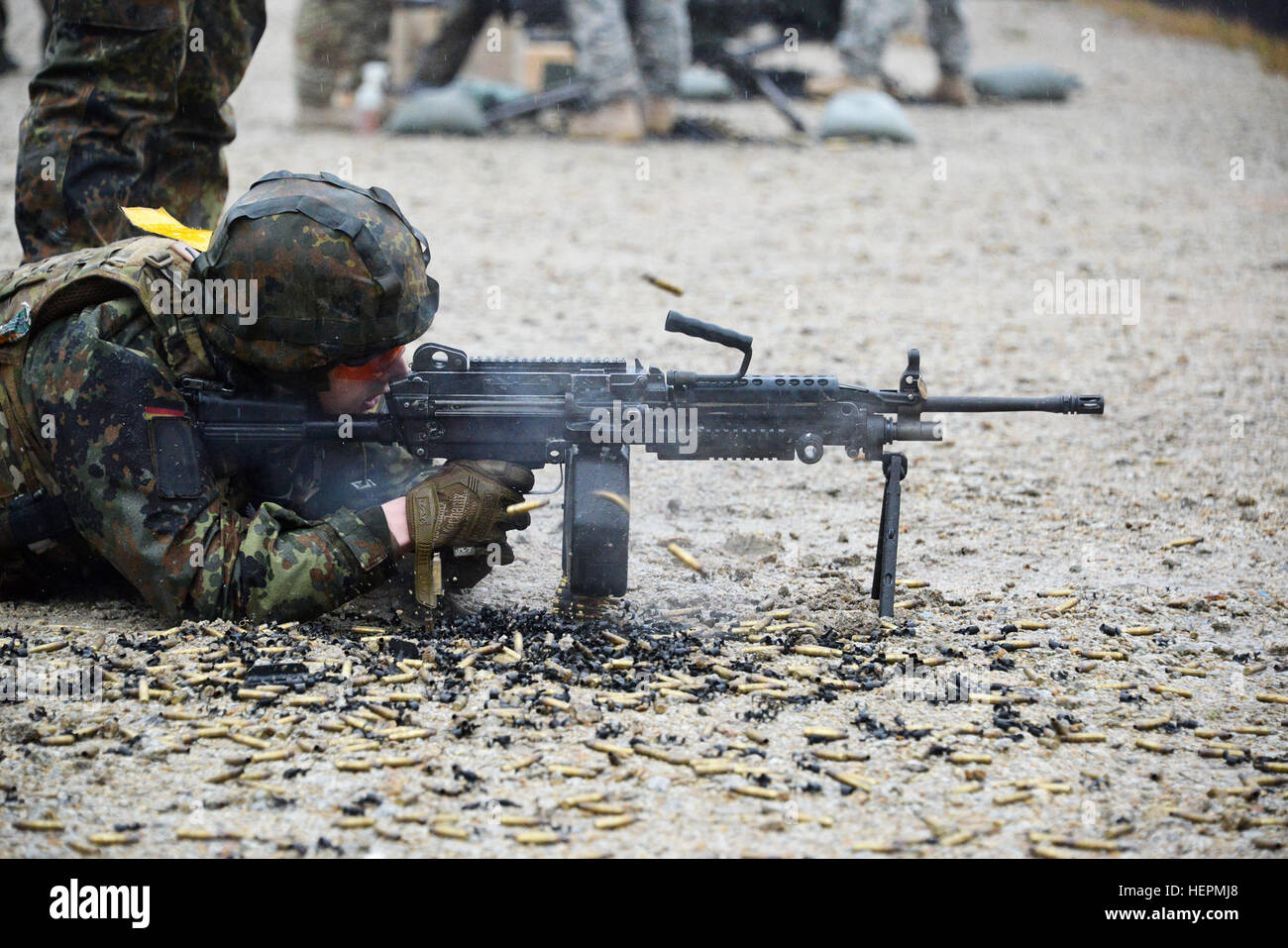 A German soldier fires a M249 light machine gun during a familiarization training on U.S. weapons at the 7th Army Joint Multinational Training Command Grafenwoehr Training Area, Germany, Dec. 9, 2015. (U.S. Army photo by Visual Information Specialist Gertrud Zach/released) CATC trains German soldiers on US weapons 151209-A-HE539-0858 Stock Photo