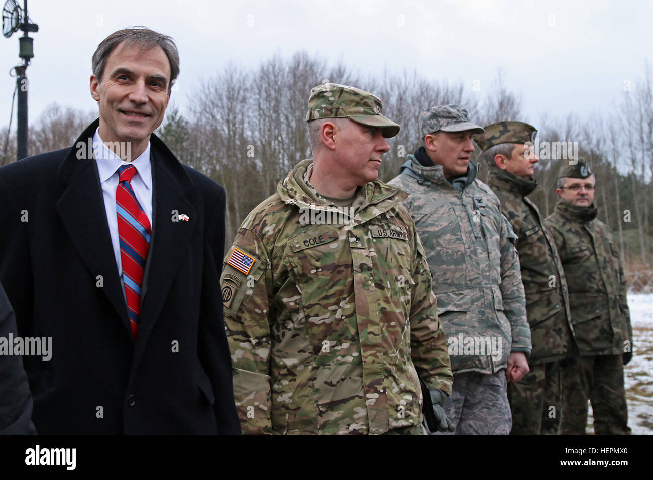Paul Jones (far left), U.S. ambassador to Poland, and Brig. Gen. William Cole (second from left), deputy commanding general of Research, Development and Engineering Command and commander of the U.S. Army Natick Soldier Systems Center, stand together during a meet and greet during Panther Assurance, an interoperability deployment readiness exercise, Jan. 16, at Skwierzyna, Poland. Jones and Cole visited 5-7 ADA’s training site along with Antoni Macierewicz, Polish minister of defense, to view 5-7 ADA’s M901 Patriot Launching Stations. Panther Assurance builds fires interoperability between the  Stock Photo