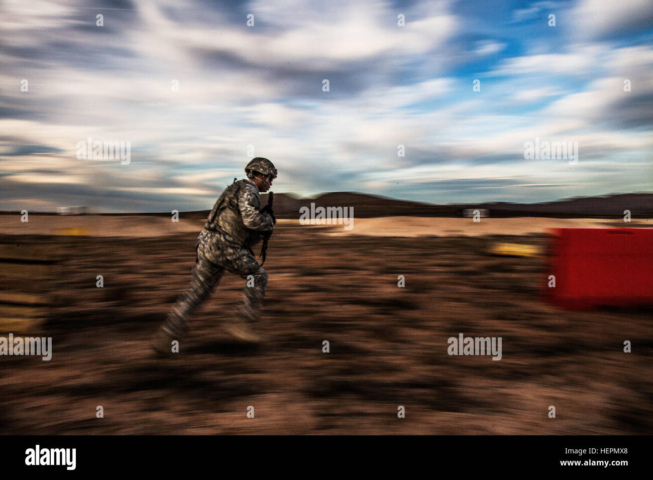 A Desert Warrior student charges across the range during a shooting competition as part of the Desert Warrior school, Iron Training Detachment, 1st Armored Division at Fort Bliss, Texas, Jan. 18, 2016. Desert Warrior, the newest squad-based leadership class in the Army, teaches soldiers how to survive and fight in a desert environment. The 17-day class is the first desert-specific Army school since the desert phase of Ranger School was discontinued in 1995. (U.S. Army photo by Staff Sgt. Marcus Fichtl) Desert Warrior range day 160118-A-TW035-002 Stock Photo