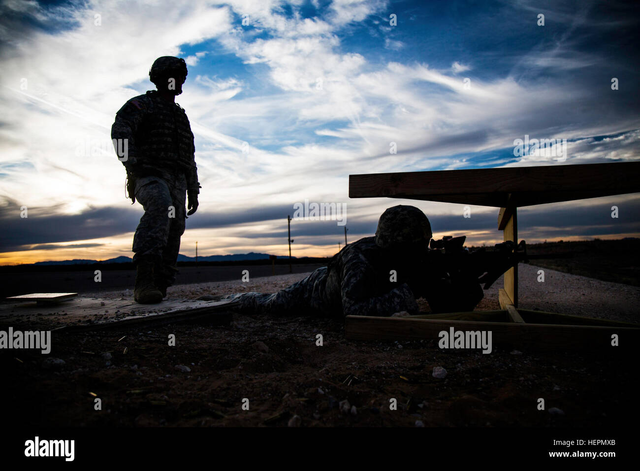 A Desert Warrior student fires behind a makeshift barrier as part of the Desert Warrior school, Iron Training Detachment, 1st Armored Division at Fort Bliss, Texas, Jan. 18, 2016. Desert Warrior, the newest squad-based leadership class in the Army, teaches soldiers how to survive and fight in a desert environment. The 17-day class is the first desert-specific Army school since the desert phase of Ranger School was discontinued in 1995. (U.S. Army photo by Staff Sgt. Marcus Fichtl) Desert Warrior range day 160118-A-TW035-007 Stock Photo