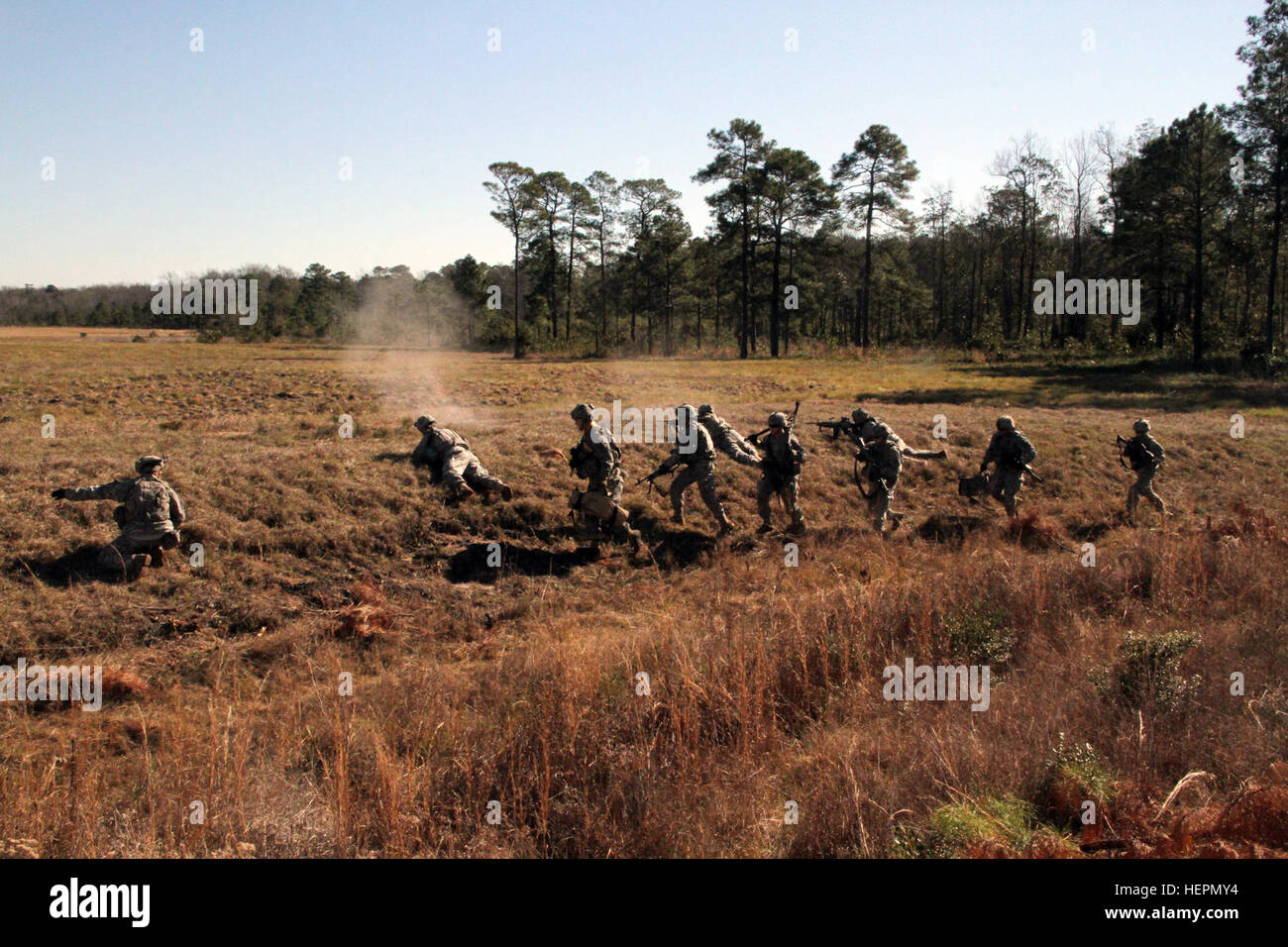 A line of infantrymen with 1st Battalion, 30th Infantry Regiment, 2nd Infantry Brigade Combat Team, 3rd Infantry Division, moves forward during a live-fire exercise at Fort Stewart, Ga., Jan. 20, 2016. The range was part of the battalion's Machine Gun Academy training, which also consisted of classroom instruction. (U.S. Army photo by Pfc. Jordan Anderson/Released) Machine Gun Academy sets standard 160120-A-XX999-244 Stock Photo