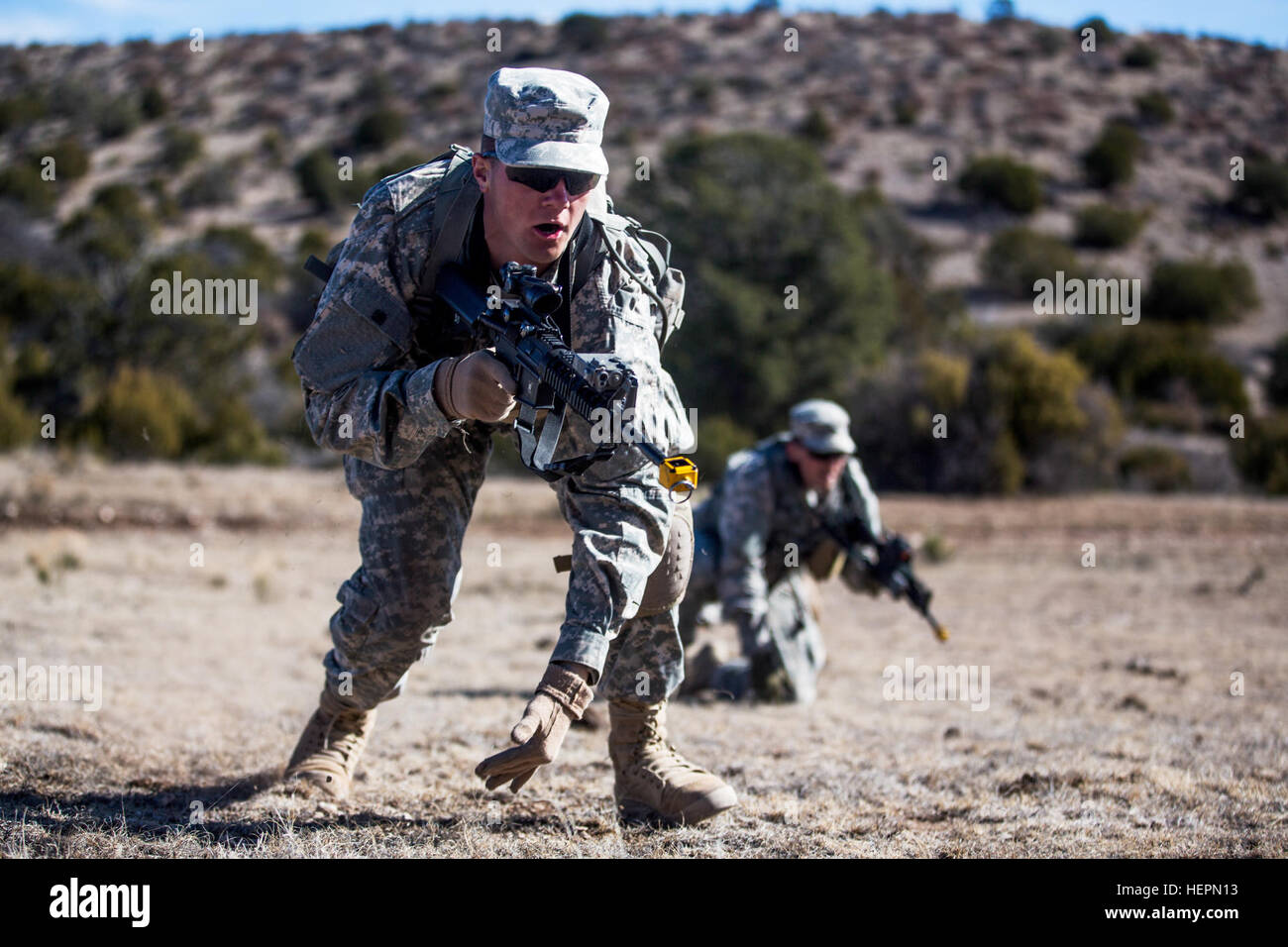 A pair of Desert Warrior students prepare to attack an enemy position during the battle drills lane as part of the Desert Warrior school, Iron Training Detachment, 1st Armored Division at Fort Bliss, Texas, Jan. 22, 2016. Desert Warrior, the newest squad based leadership class in the Army, teaches soldiers how to survive and fight in a desert environment. The 17-day class is the first desert specific Army school since the desert phase of Ranger School was discontinued in 1995. (U.S. Army photo by Staff Sgt. Marcus Fichtl) Desert Warrior battle drills 160122-A-TW035-343 Stock Photo