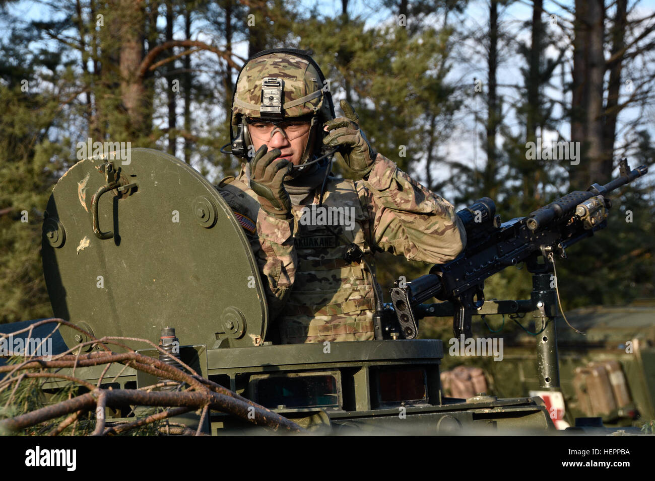 A trooper assigned to Reaper Troop, 4th Squadron, 2nd Cavalry Regiment, checks his headset while riding in the gunner's position of an M1134 Anti-Tank Guided Missile Vehicle before heading out to the range for the squadron's live-fire exercise at the Grafenwoehr Training Area, located near Rose Barracks, Germany, March 15, 2016. The purpose of the live-fire exercise was to help validate the regiment's mission command platforms while conducting  a capstone-training event that includes a transition from movement to maneuver capabilities. (U.S. Army photo by Sgt. William A. Tanner) Reaper Troop,  Stock Photo