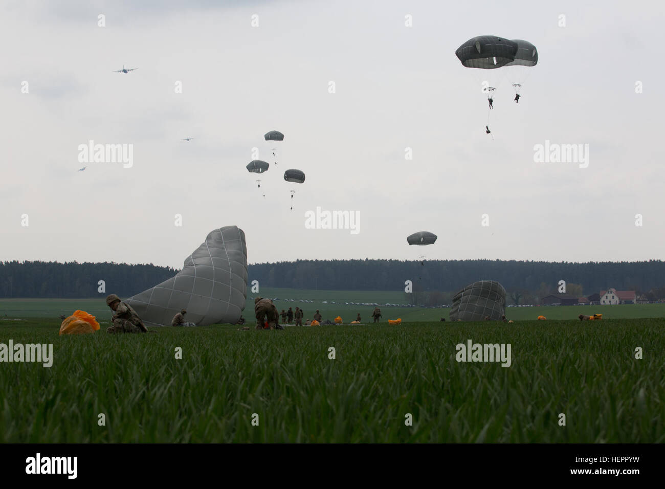U.S. Soldiers of the 173rd Airborne Brigade parachute and secure gear while conducting an airborne operation during exercise Saber Junction 16 at the German Maneuver Rights Area outside Hohenfels, Germany, April 12, 2016. Saber Junction 16 is the U.S. Army Europe’s 173rd Airborne Brigade’s combat training center certification exercise, taking place at the JMRC in Hohenfels, Germany, Mar. 31-Apr. 24, 2016.  The exercise is designed to evaluate the readiness of the Army’s Europe-based combat brigades to conduct unified land operations and promote interoperability in a joint, multinational enviro Stock Photo