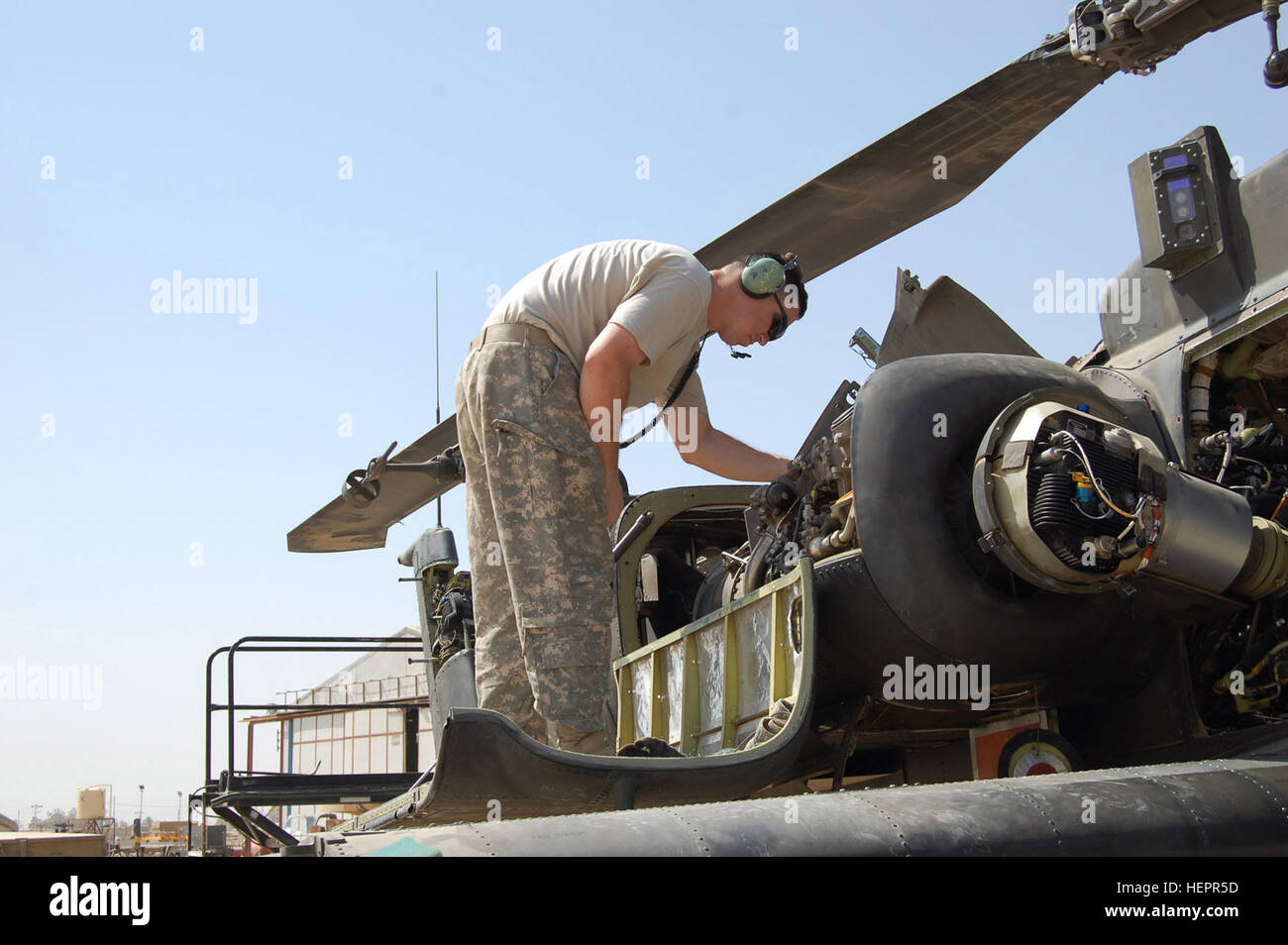 CAMP TAJI, Iraq – Spc. Charles Carrington, maintainer, Company B, 404th Aviation Support Battalion, Combat Aviation Brigade, 4th Infantry Division, Multi-National Division – Baghdad from Cedarville, Ohio, checks through an Apache attack helicopter as part of phase maintenance on Camp Taji Sept. 18.  (U.S. Army photo by Sgt. 1st Class Brent Hunt, CAB PAO, 4th Inf. Div., MND-B) Maintainers keep CAB war birds in tip-top shape 116425 Stock Photo