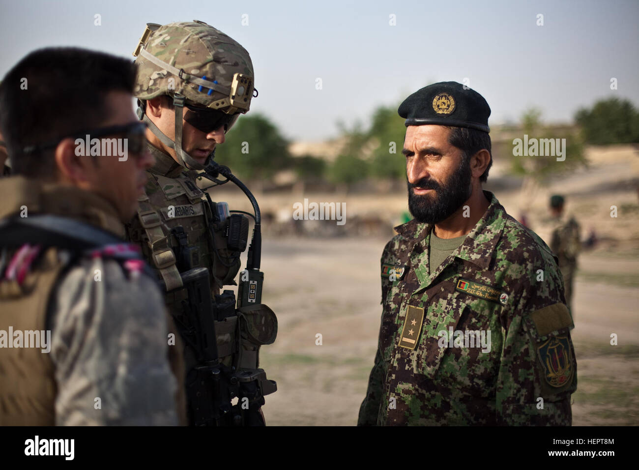 An Afghan National Army officer speaks to Charlie Company's commander during a clearing mission with U.S. Army soldiers assigned to Charlie Company, 1st Battalion, 24th Infantry Regiment, 2nd Brigade, 25th Infantry Division, to clear the village of Nawrak, Afghanistan, June 26, 2011. The Afghan National Police actively search the houses in the village while the Afghan National Army and U.S. Army soldiers provide security. Kalat District ANP patrol in Nawrak 110626-A-UJ825-033 Stock Photo