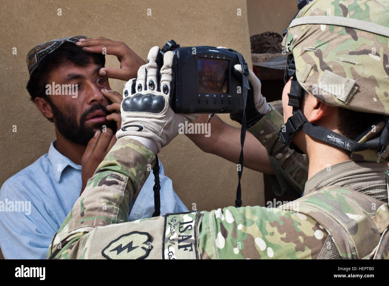 A U.S. Army soldier assigned to Charlie Company, 1st Battalion, 24th Infantry Regiment, 2nd Brigade, 25th Infantry Division, performs a retina scan during a mission  to clear the village of Nawrak, Afghanistan, June 26, 2011. The Afghan National Police actively search the houses in the village while the Afghan National Army and U.S. Army soldiers provide security. Kalat District ANP patrol in Nawrak 110626-A-UJ825-103 Stock Photo