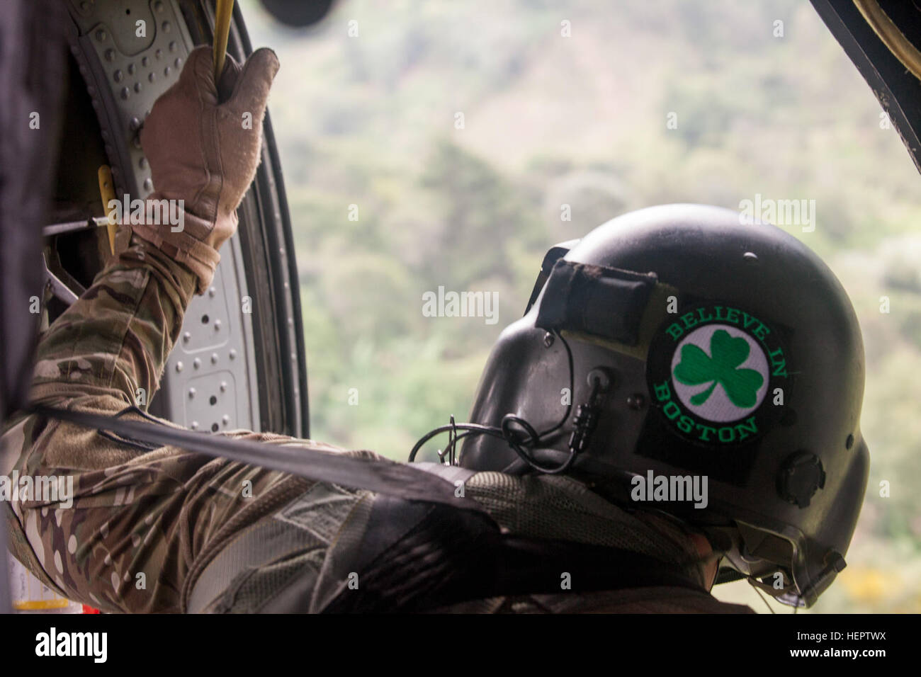 U.S. Army Sgt. John Cooney of the 238th Task Force Medical Evacuation Company, New Hampshire National Guard, scans his surroundings to avoid obstacles while flying in a UH-60 Black Hawk helicopter in Coatepeque, Guatemala, May 27, 2016. Task Force Red Wolf and Army South conducts Humanitarian Civil Assistance Training to include tatical level construction projects and medical readiness Training Exercises providing medical access and building schools in guatemala with the Guatamalan Government and non government agencies from 05Mar16 to 18JUN16 in order to improve the mission readiness of US Fo Stock Photo