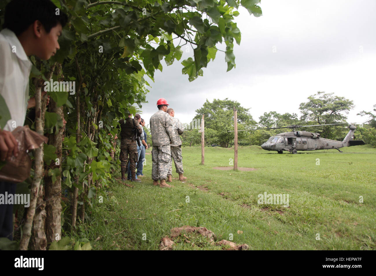 Guatemalan citizens watch as U.S. Army Brig. Gen. Keith Klemmer's, the Arkansas deputy adjutant general, UH-60 Black Hawk helicopter, take off at Catarina construction site, Guatemala, June 8, 2016. Task Force Red Wolf and Army South conducts Humanitarian Civil Assistance Training to include tactical level construction projects and Medical Readiness Training Exercises providing medical access and building schools in Guatemala with the Guatemalan Government and non-government agencies from 05MAR16 to 18JUN16 in order to improve the mission readiness of US forces and to provide a lasting benefit Stock Photo