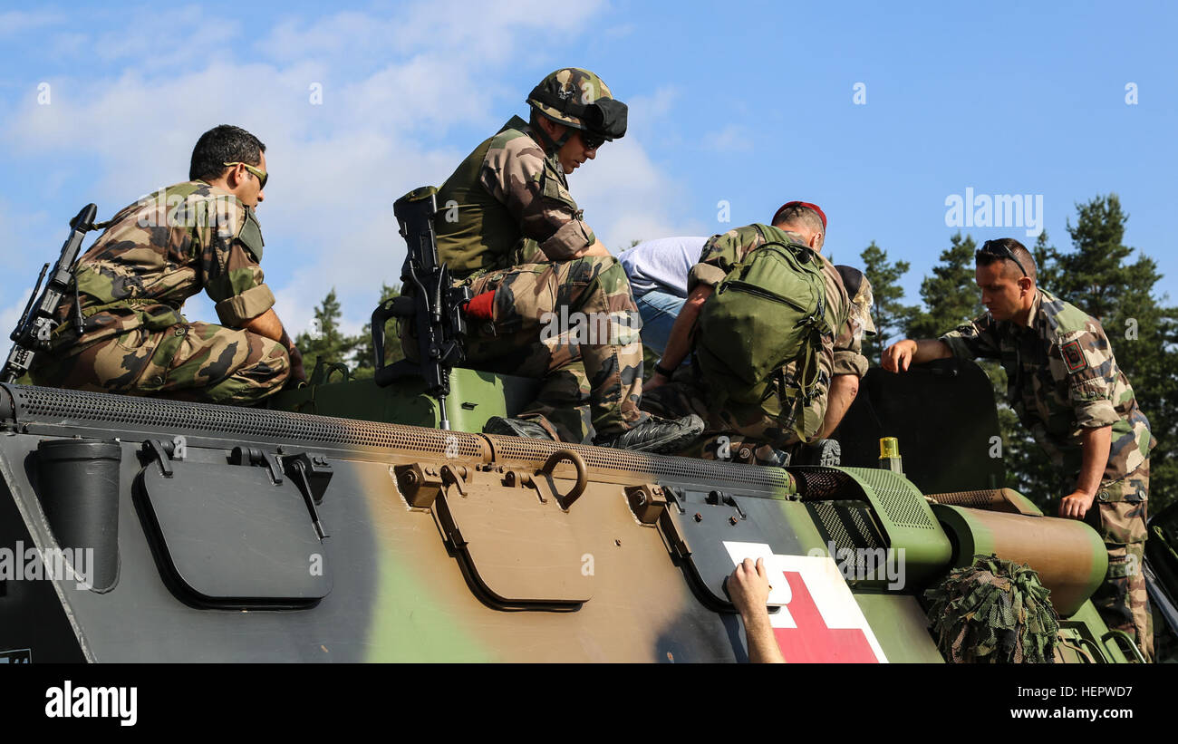 French soldiers of the 17th Parachute Engineer Regiment diagnose installation problems while conducting Multiple Integrated Laser Engagement System (MILES) installation for Swift Response 16 training exercise at the Grafenwoehr Training Area, a part of the Joint Multinational Readiness Center, in Grafenwoehr, Germany, Jun. 10, 2016. Exercise Swift Response is one of the premier military crisis response training events for multi-national airborne forces in the world. The exercise is designed to enhance the readiness of the combat core of the U.S. Global Response Force – currently the 82nd Airbo Stock Photo