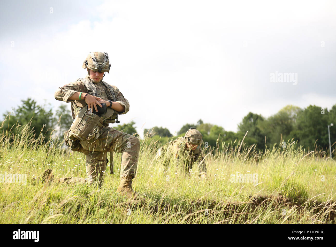 A British soldier of Airborne Combined Joint Expeditionary Force secures his productive mask while conducting tactical operations during Swift Response 16 training exercise at the Hohenfels Training Area, a part of the Joint Multinational Readiness Center, in Hohenfels, Germany, Jun. 22, 2016. Exercise Swift Response is one of the premier military crisis response training events for multi-national airborne forces in the world. The exercise is designed to enhance the readiness of the combat core of the U.S. Global Response Force – currently the 82nd Airborne Division’s 1st Brigade Combat Team – Stock Photo