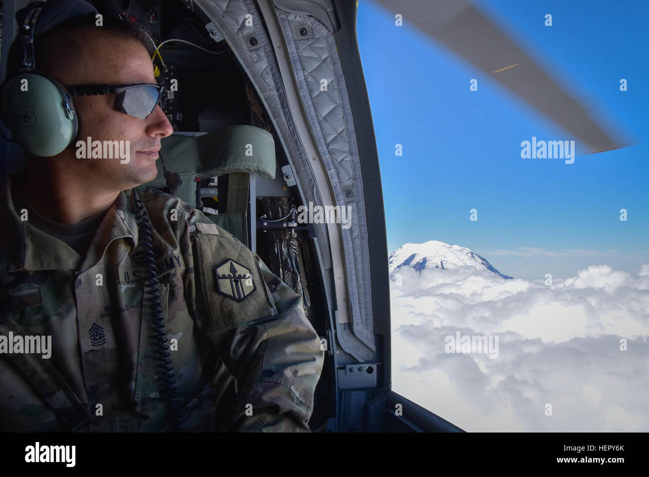 U.S. Army Reserve Command Sgt. Maj. Thomas C. Perry, 301st Maneuver Enhancement Brigade (MEB) command sergeant major, enjoys the view from a CH-47 Chinook, July 22, 2016, near the top of Mount Rainier, Washington.  Perry along with other U.S. Army Reserve soldiers participated in a flyover of Mount Rainier, Joint Base Lewis-McChord and Yakima Training Center by the U.S. Army Reserve 1-214th General Support Aviation Battalion, Bravo Company,  based out of Joint Base Lewis-McChord.  (U.S. Army photo by Master Sgt. Marisol Walker/Released) Enjoying the view 160722-A-EK876-048 Stock Photo