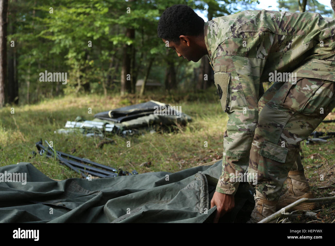 A U.S. Soldier of the 44th Expeditionary Signal Battalion gathers tarps