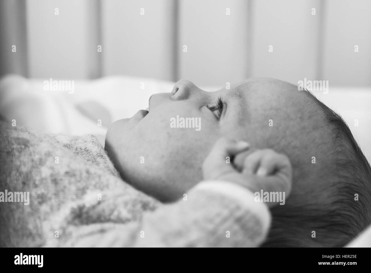Baby girl lying in cot Stock Photo Alamy