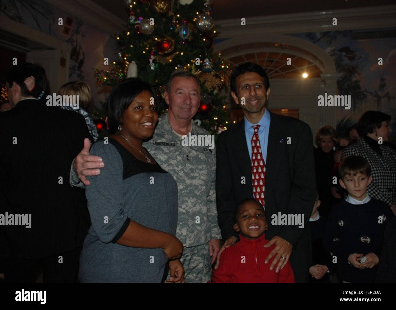 BATON ROUGE, La. – Louisiana Governor Bobby Jindal and Louisiana National Guard Adjutant General Maj. Gen. Bennett C. Landreneau stand with Latesha P. Pigford and her five-year-old son Xavier at a ceremonial Christmas tree lighting honoring the families of deployed Louisiana National Guard Soldiers at the Governor’s Mansion in Baton Rouge, La., Dec. 5.  Pigford’s husband, Spc. Omar K. Pigford, is currently deployed to Iraq with the 39th Military Police Company, 773rd Military Police Battalion.  (U.S. Army Photo by Sgt. Beyonka D. Joseph, Greater New Orleans Unit Public Affairs Representative)  Stock Photo