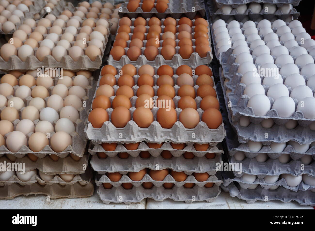 Giant cardboard crates of fresh white, yellow and brown eggs at the market Stock Photo