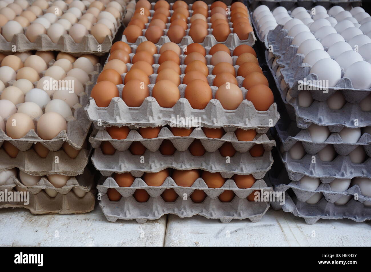 Giant cardboard crates of fresh white, yellow and brown eggs at the market Stock Photo