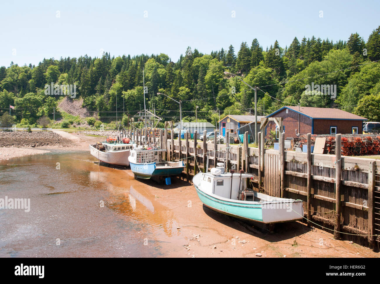 Boats are resting during the low tide in high tide famous St. Martins village (New Brunswick, Canada). Stock Photo