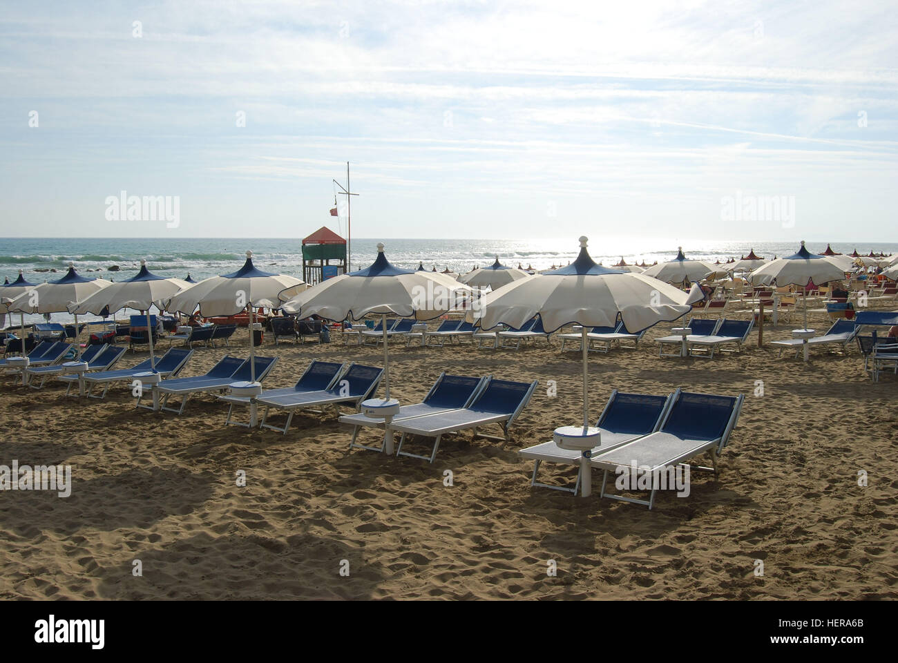 Aufgreihte Strandliegen und Sonnenschirme in einem italienischen Strandbad bei Castiglione della Pescaia, Toskana Stock Photo