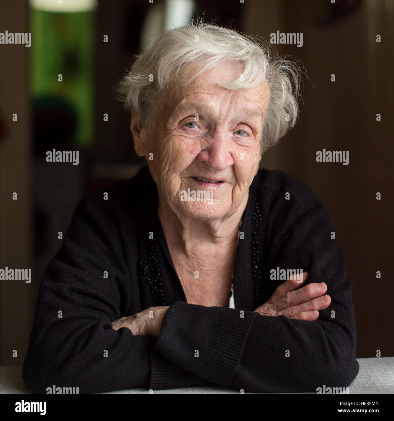 Elderly woman sitting at the table. Stock Photo