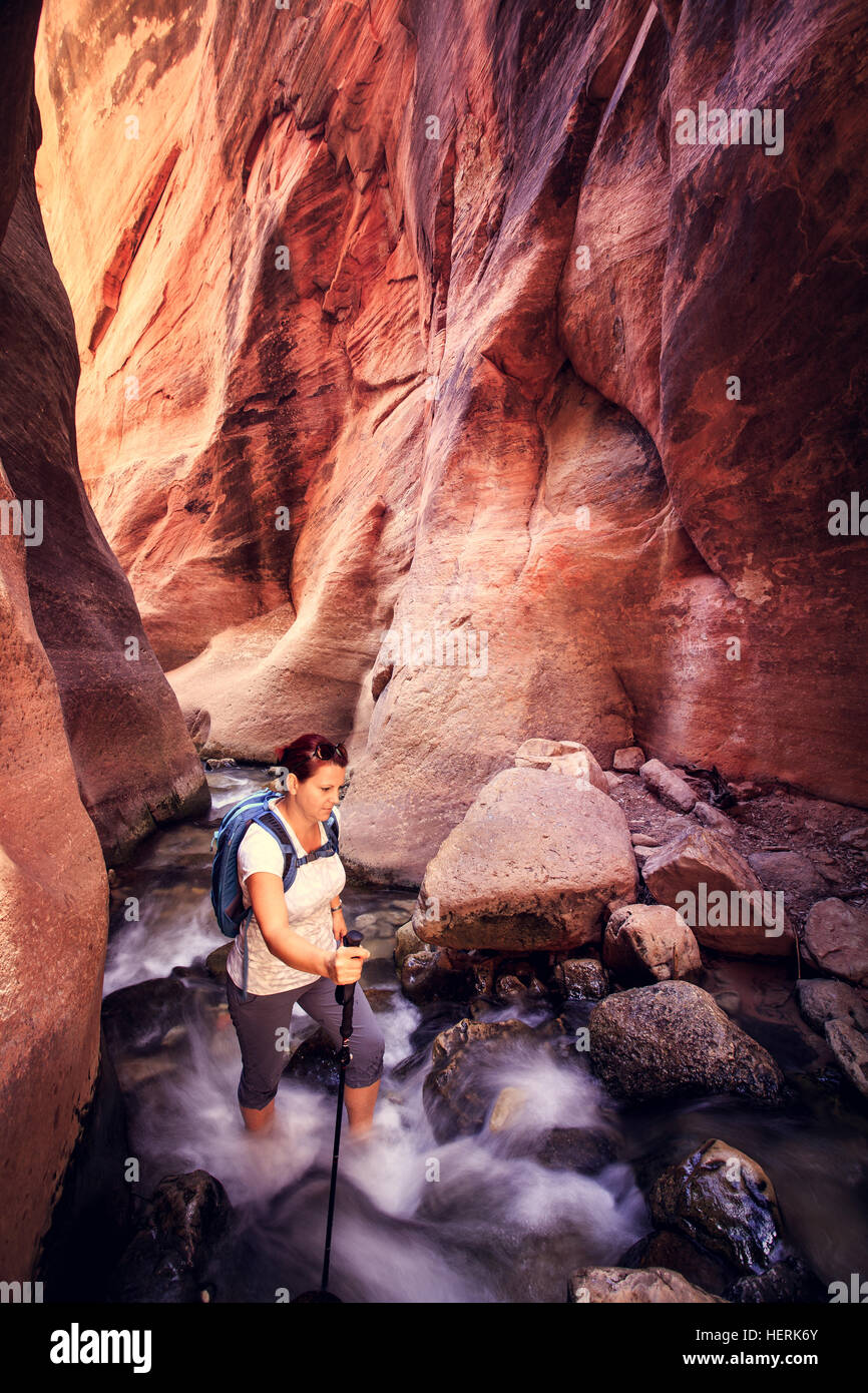 Woman hiking through a creek, slot canyon, Kanarra mountain, Utah, United States Stock Photo