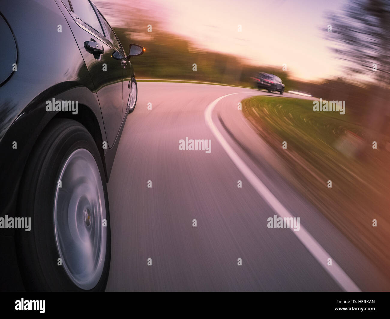 Car driving at speed on curved road Stock Photo - Alamy