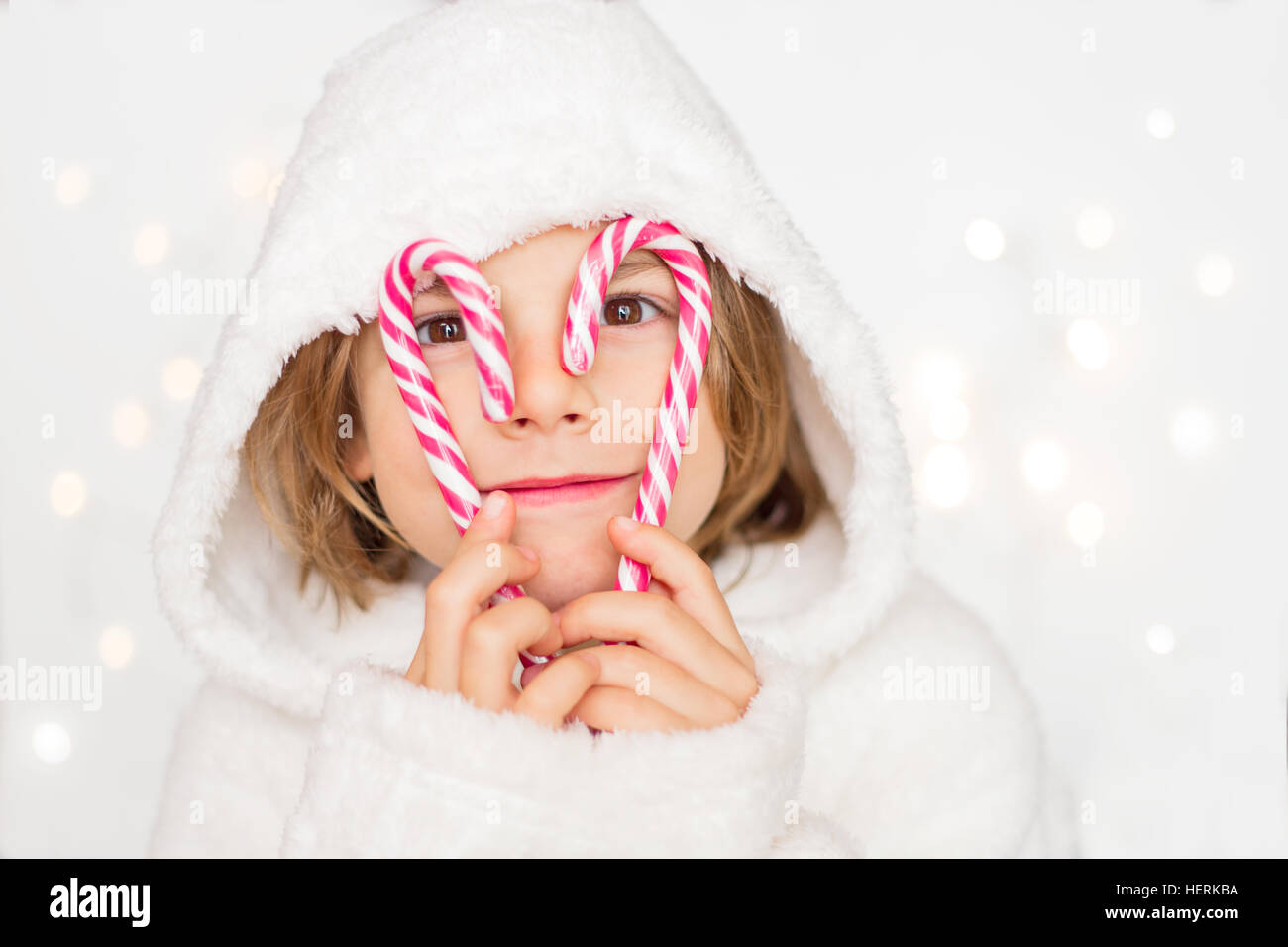 Boy holding candy canes in front of his face Stock Photo Alamy