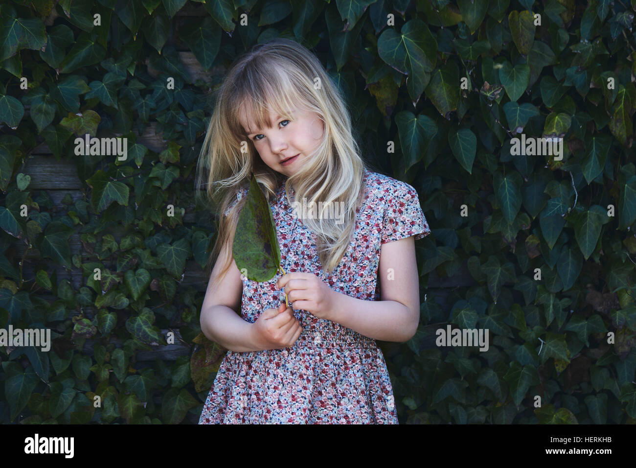 Portrait of a girl holding a leaf Stock Photo - Alamy