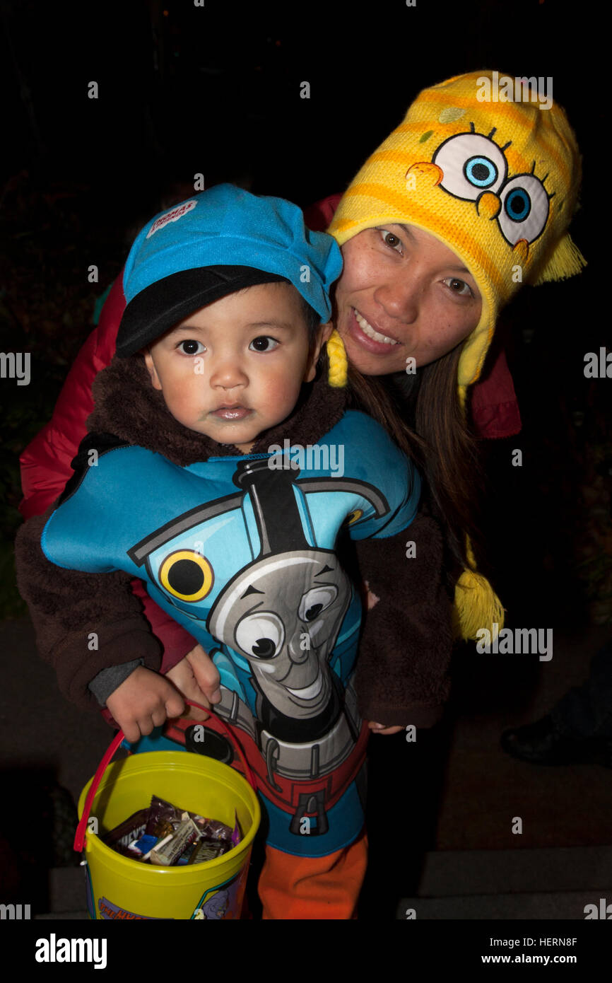 A good mom propping up her son in a Halloween Thomas the Train costume out for tricks and treats. St Paul Minnesota MN USA Stock Photo