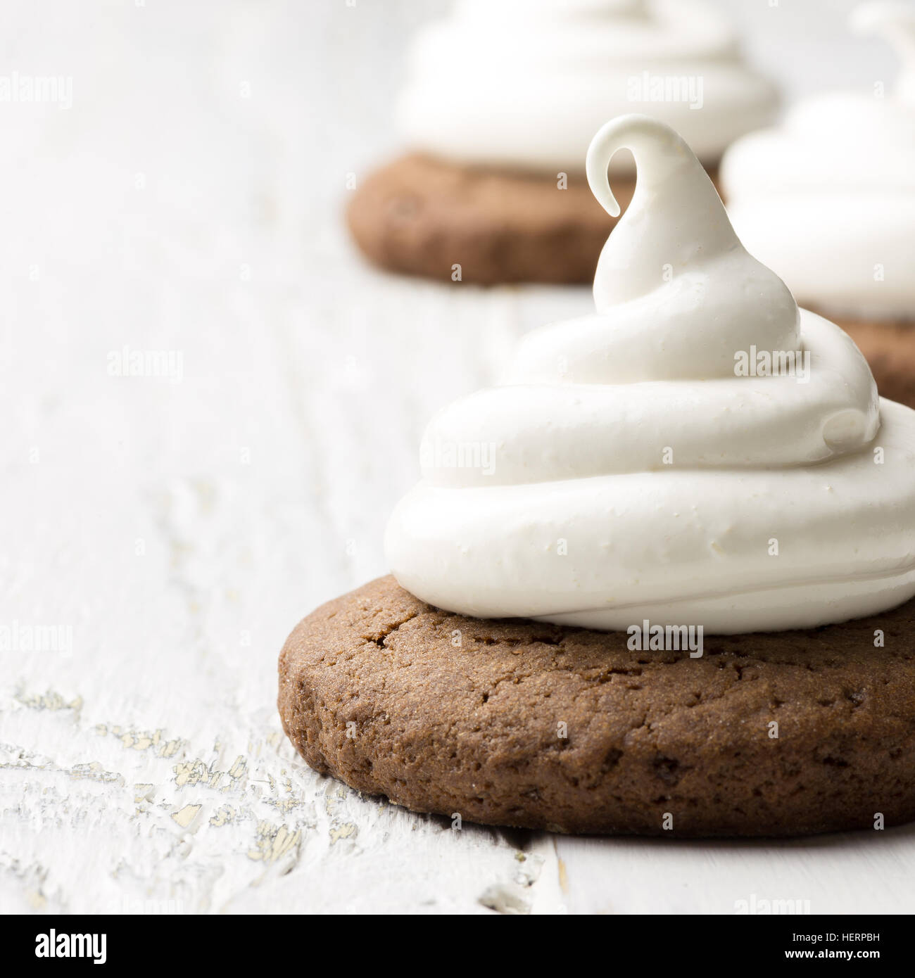 Hot chocolate cookies with marshmallow meringue on white rustic