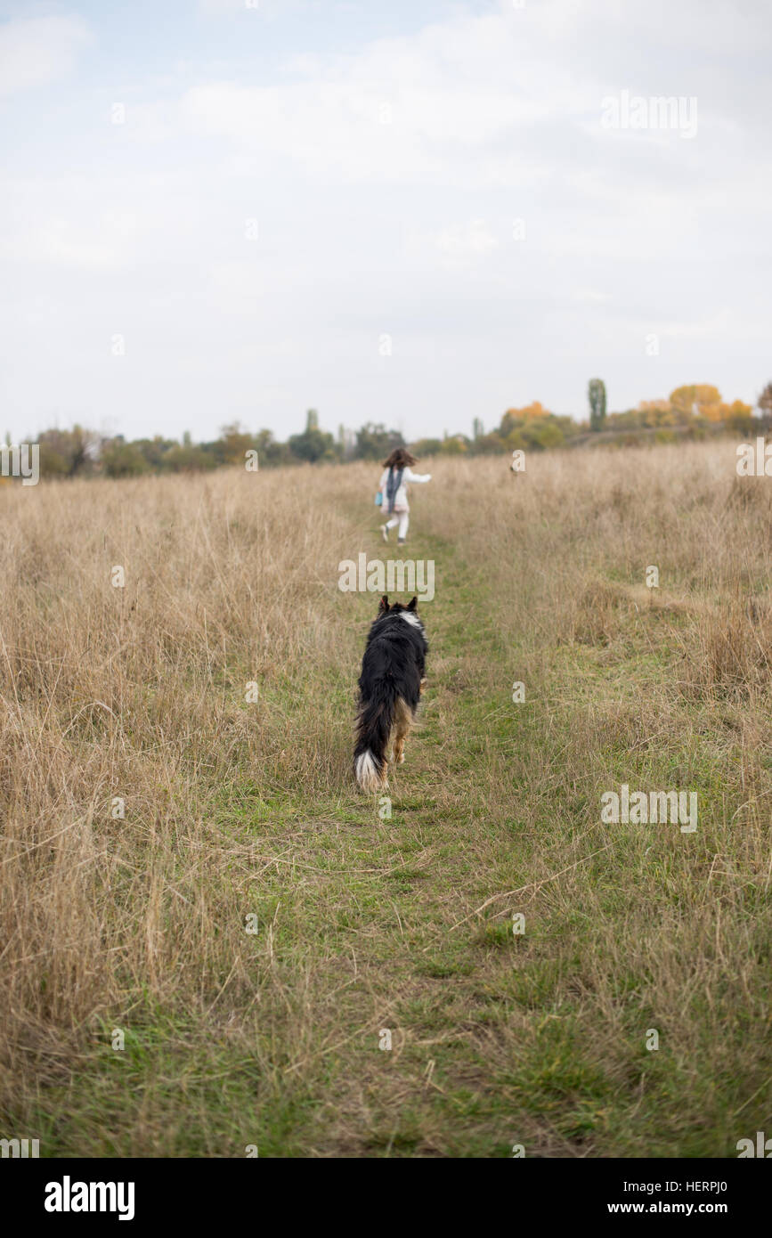 Girl running with her dog Stock Photo