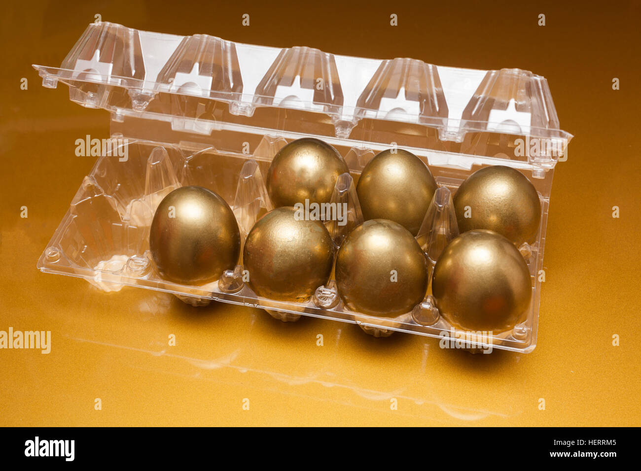 Golden eggs in a plastic box on golden background Stock Photo Alamy
