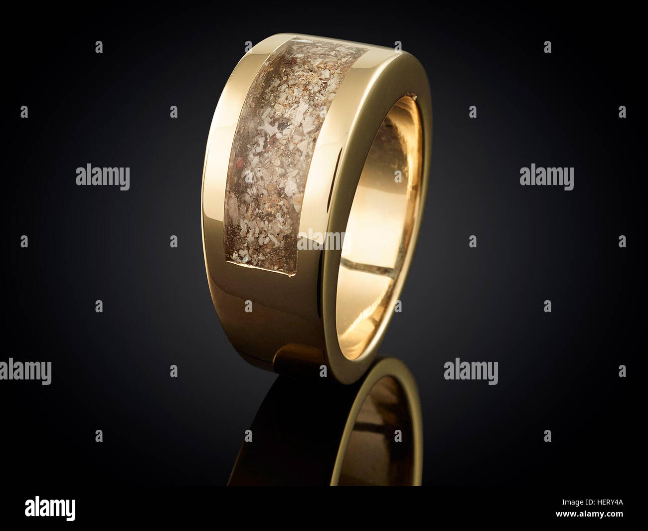 Golden ring with ashes isolated on black . Stock Photo