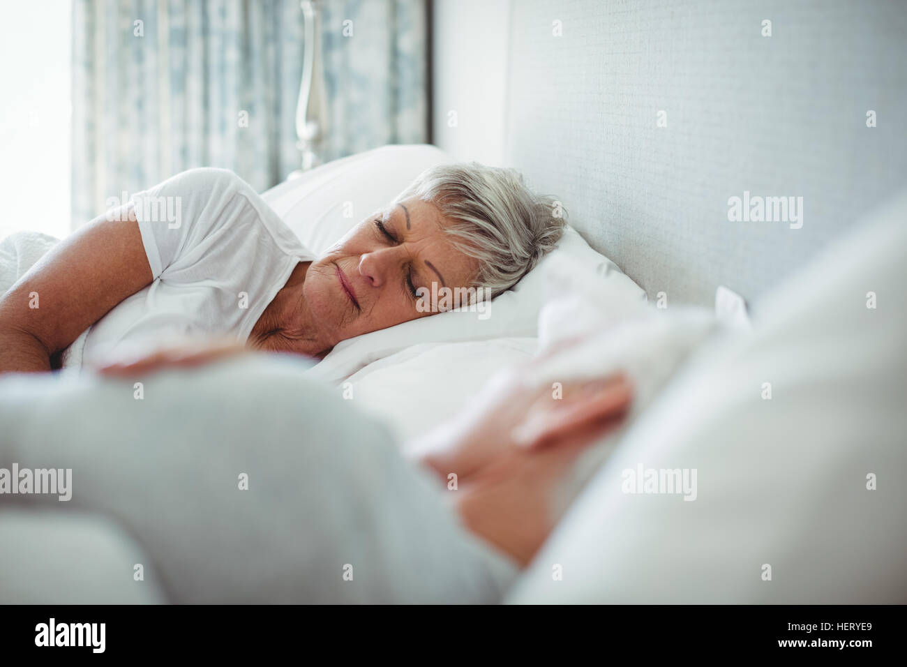 Senior couple sleeping on bed in bedroom Stock Photo - Alamy