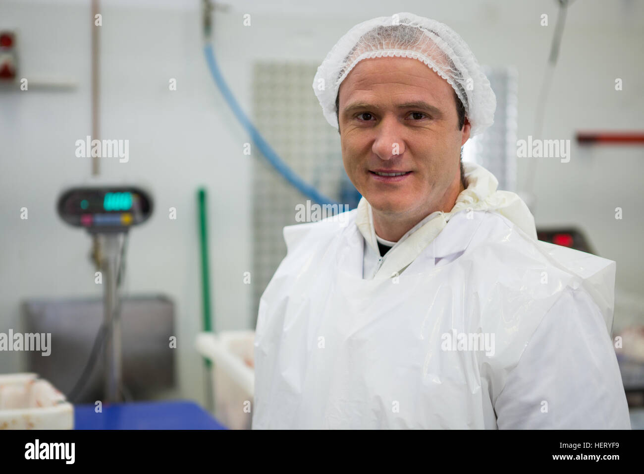 Portrait of smiling butcher standing in meat factory Stock Photo Alamy