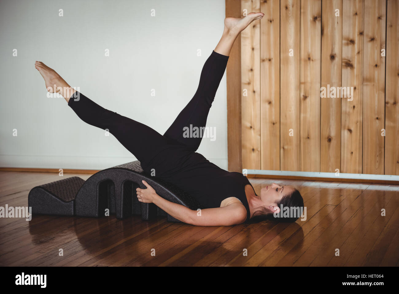 Woman exercising with yoga back arch in fitness studio Stock Photo - Alamy