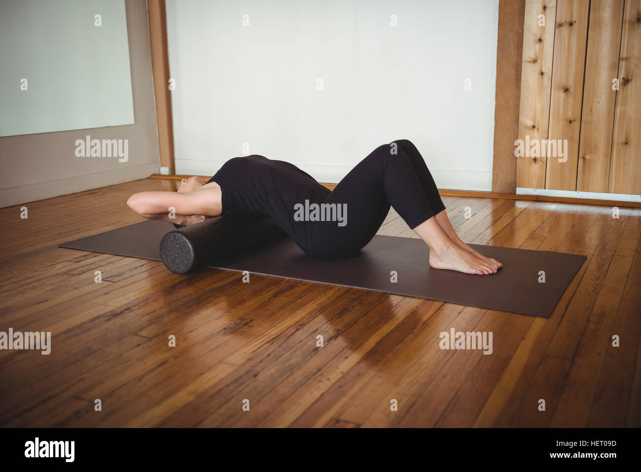Woman exercising with foam roll in fitness studio Stock Photo - Alamy