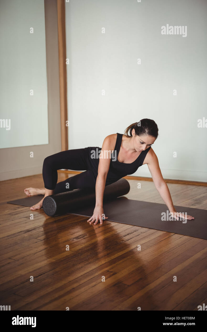 Woman exercising with foam roll in fitness studio Stock Photo - Alamy