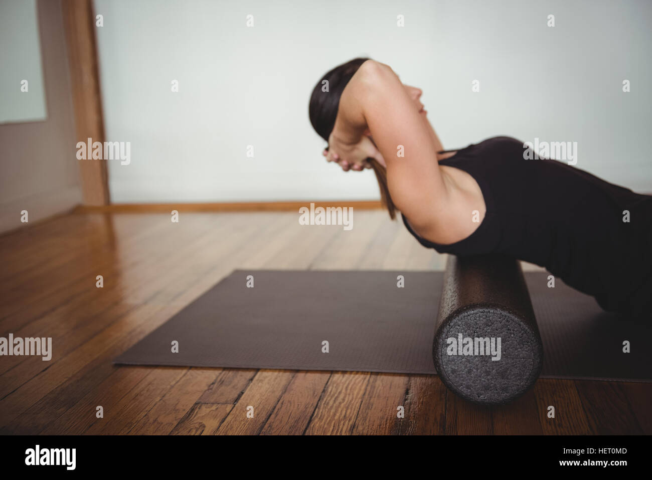 Woman exercising with foam roll in fitness studio Stock Photo - Alamy