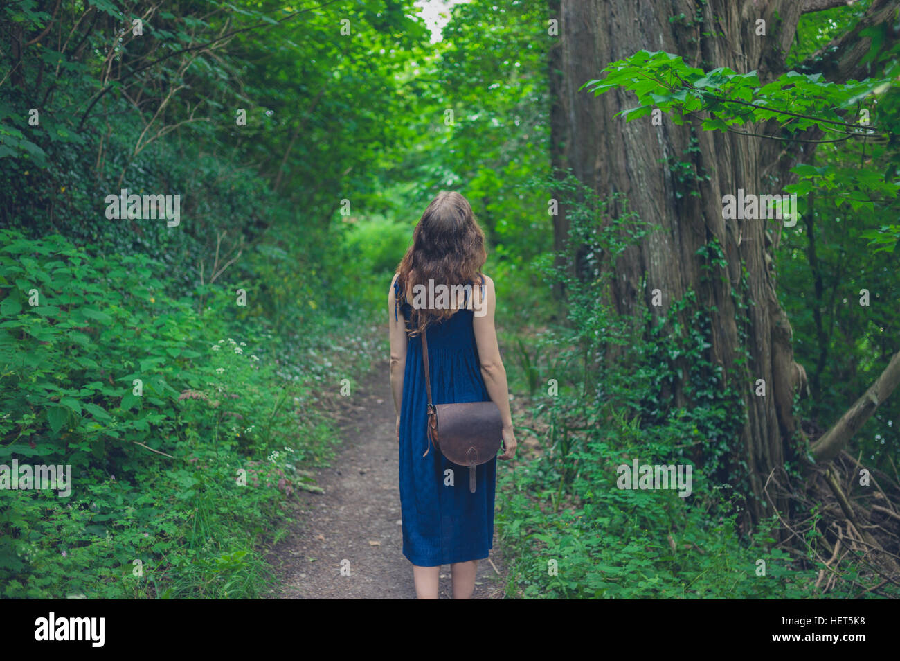 A young woman is walking in a forest Stock Photo - Alamy